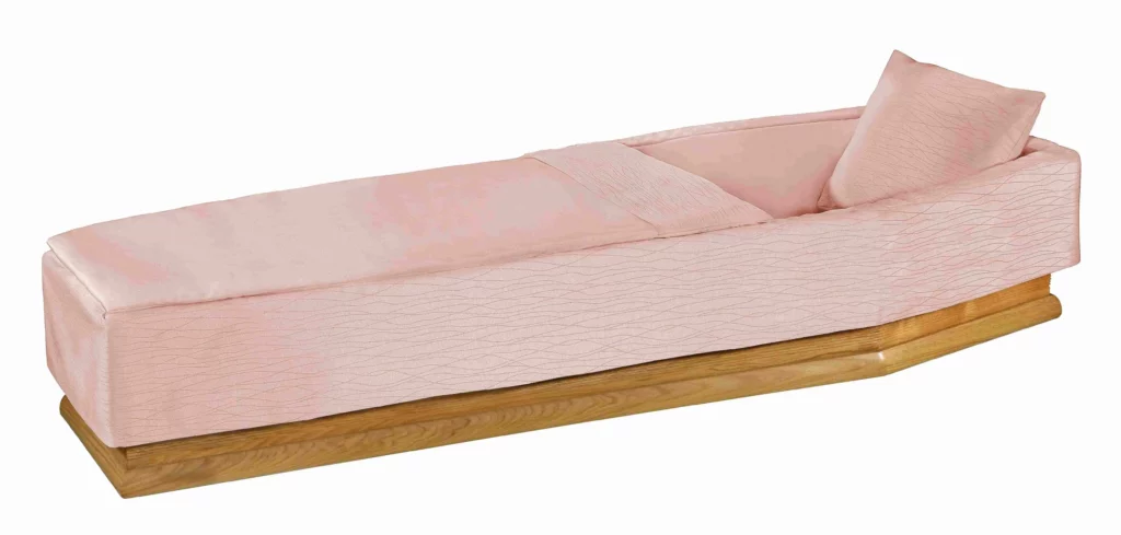 Capiton de cercueil rose poudré texturé avec oreiller assorti.