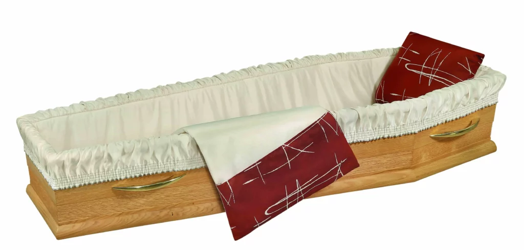 Capiton de cercueil en tissu beige clair avec oreiller et rabat bordeaux.
