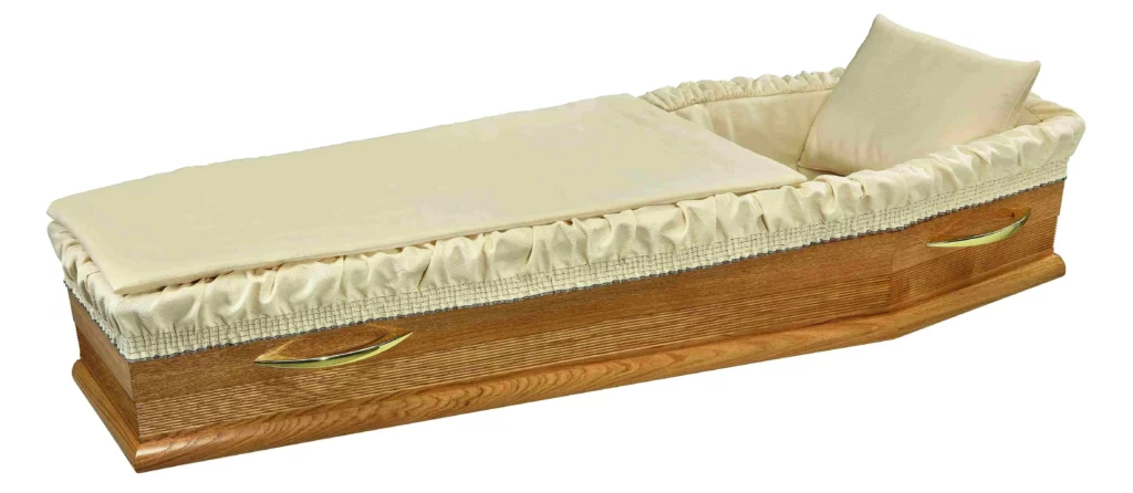 Capiton funéraire beige clair uni avec oreiller et entourage plissé.
