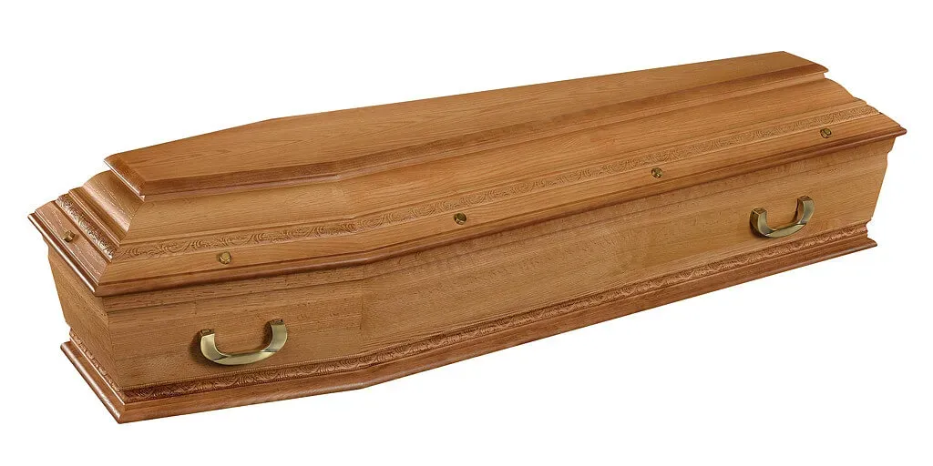 Cercueil de finition traditionnelle en bois teinté miel avec frises sculptées.
