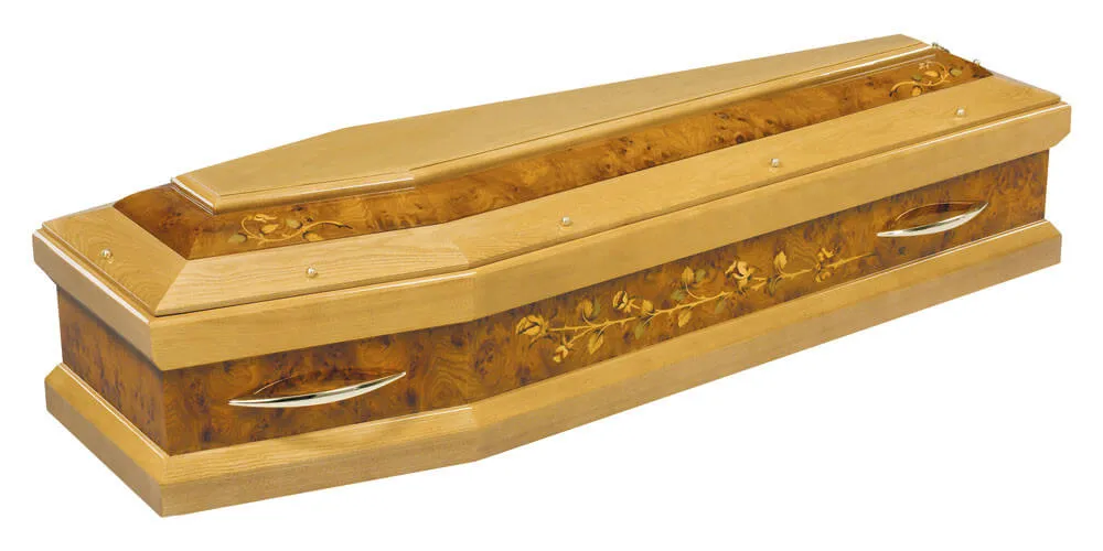 Cercueil en bois clair vernis avec motifs floraux sculptés en marqueterie.