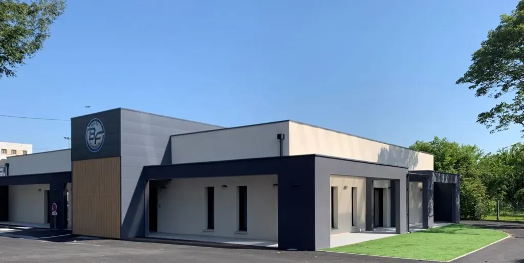 Façade moderne du complexe funéraire Beuze sous un ciel bleu.