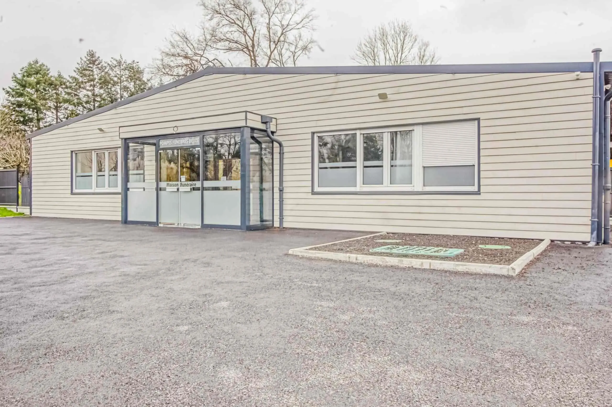 Extérieur du bâtiment de la maison funéraire Beuze et son parking dédié.